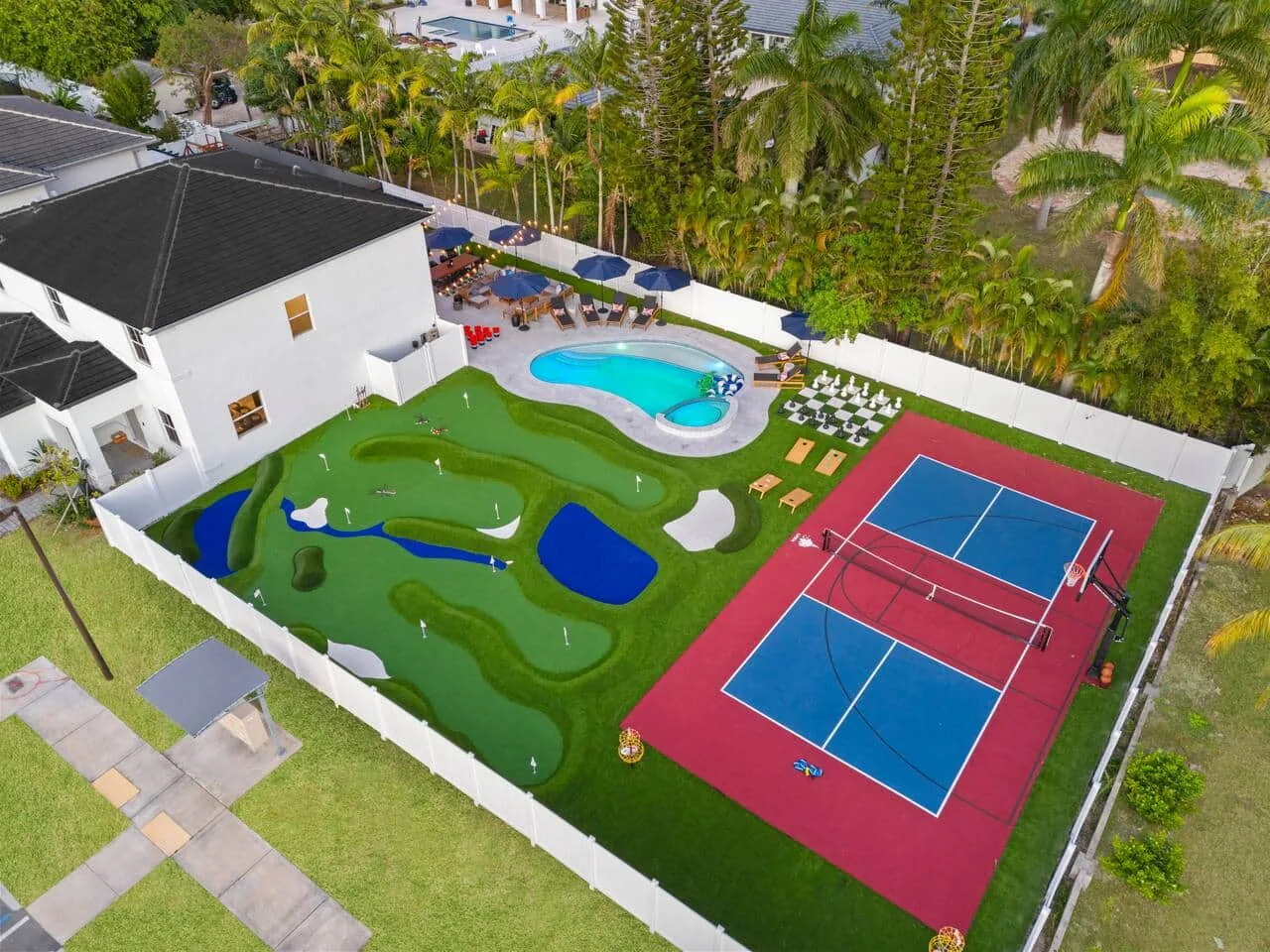Aerial view of the yard at dusk with the pool lit