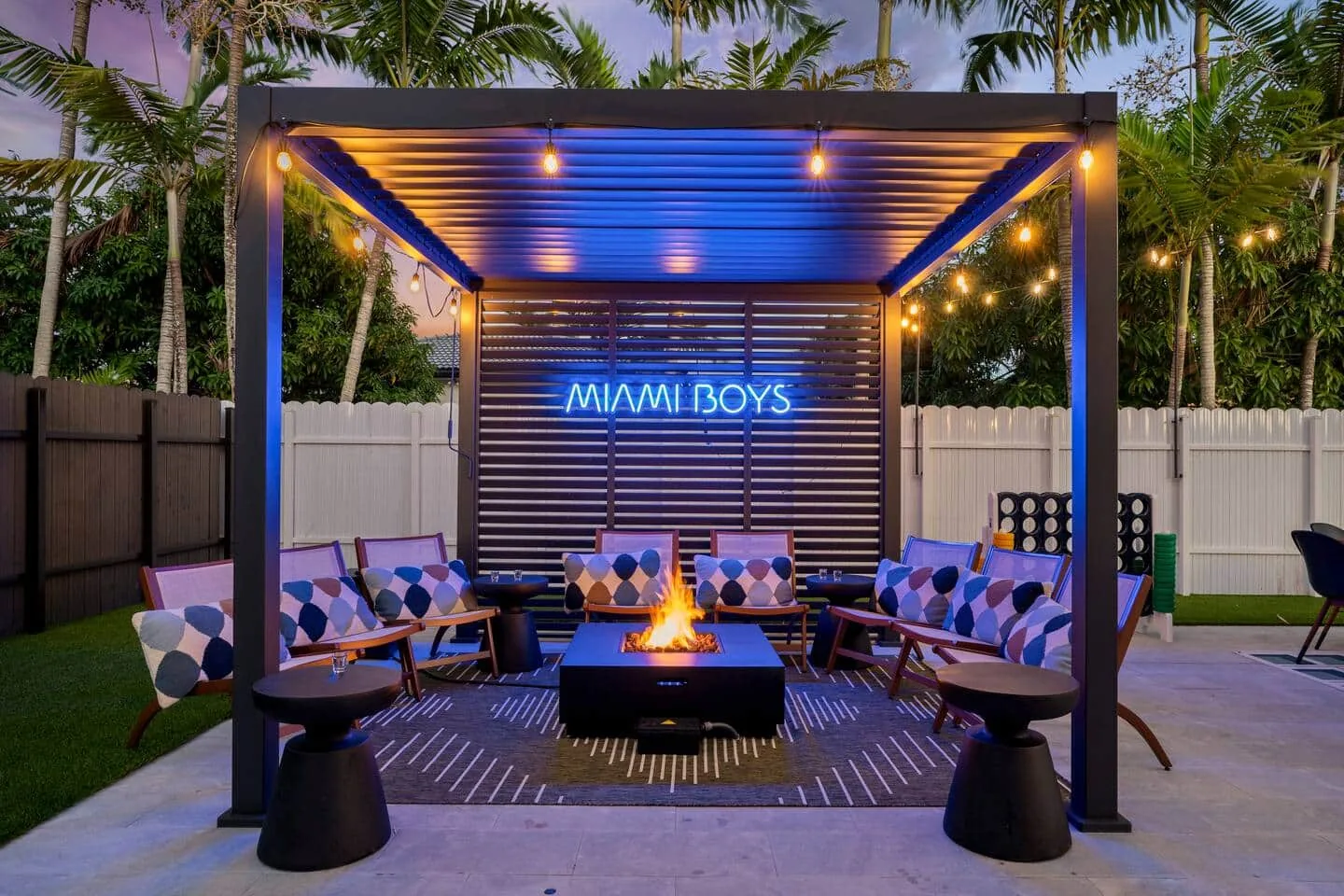Fire pit under the pergola with the Miami Boys neon sign