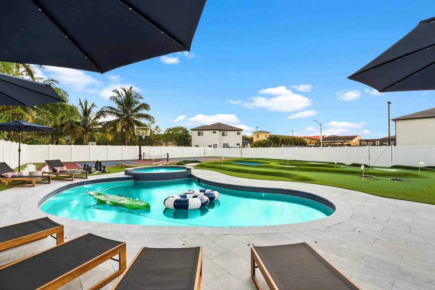 Pool with floats and loungers under the umbrellas